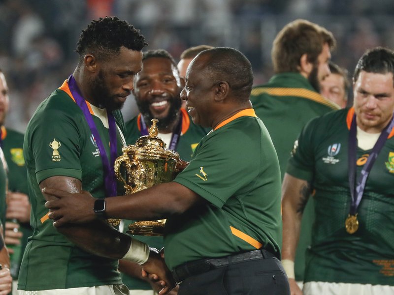South Africa's President Cyril Ramaphosa (C) congratulates South Africa's flanker Siya Kolisi (L) as they celebrate winning the Japan 2019 Rugby World Cup  / AFP