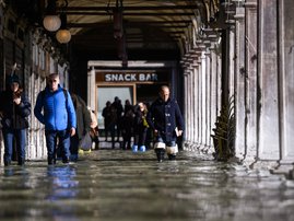 People walk across a floode darcade by St. Mark's Square on November 14, 2019 in Venice.