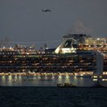 A small boat is pictured next to the Diamond Princess cruise ship with over 3,000 people as it sits anchored in quarantine off the port of Yokohama on February 4, 2020, a day after it arrived with passengers feeling ill. Japan has quarantined the cruise s