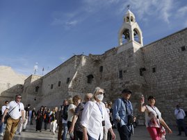 People wearing masks visit the Church of the Nativity, revered as the birthplace of Jesus Christ, in the West Bank city of Bethlehem on March 5, 2020. The Palestinian health ministry called for local churches, mosques and other institutions to close after