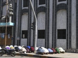 Muslim devotees offer Friday prayers outside a closed mosque alongside a street during a government-imposed nationwide lockdown as a preventive measure against the COVID-19 coronavirus, in Karachi on April 3, 2020.