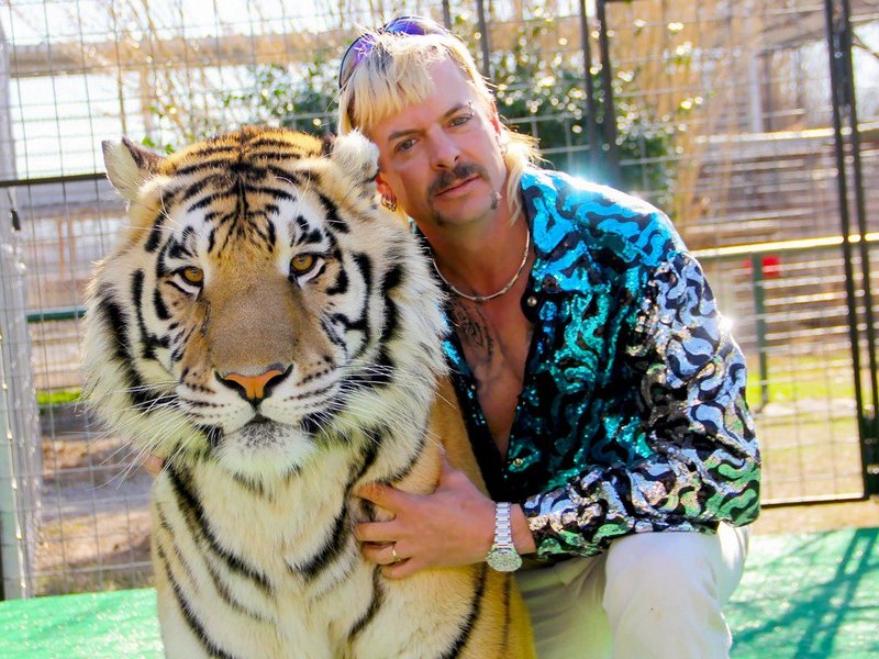 This undated photo courtesy of Netflix shows Joseph "Joe Exotic" Maldonado-Passage with one of his tigers. Amid a constant swirl of grim coronavirus news, the surreal tale of a gay, mullet-wearing private zookeeper who calls himself "Joe Exotic" -- now in