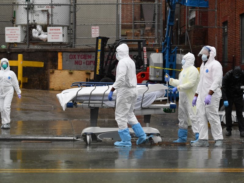 Medical personnel move a deceased patient to a refrigerated truck serving as make shift morgues at Brooklyn Hospital Center on April 09, 2020 in New York City. America's coronavirus epicenter of New York recorded a new single-day high of 799 COVID-19 deat
