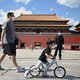 People wearing face masks walk in front of the entrance of the Forbidden City, while the closing of the Chinese People’s Political Consultative Conference takes place in Beijing on May 27, 2020.