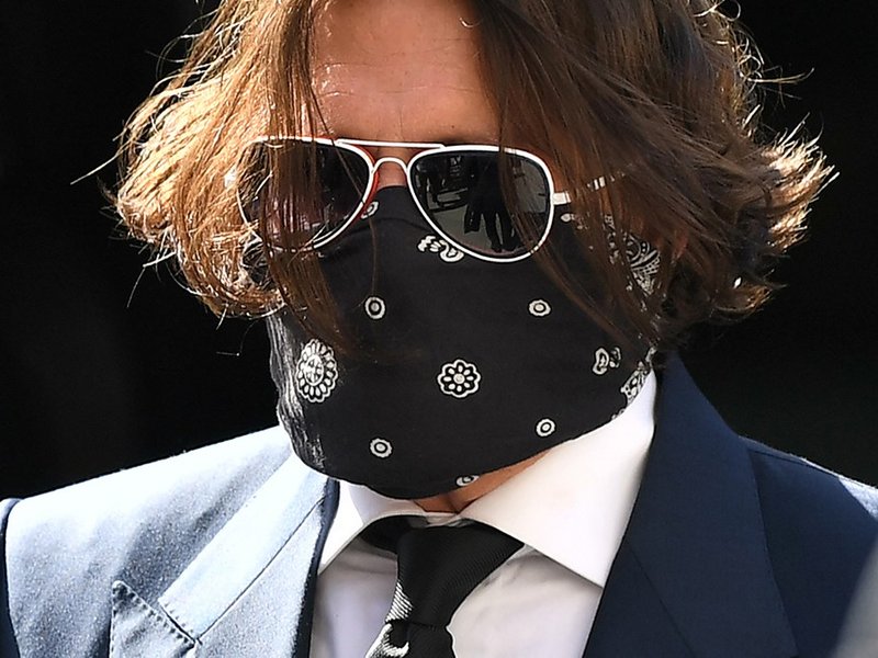Hollywood actor Johnny Depp (3R), wearing a face mask or covering due to the COVID-19 pandemic, arrives on the first day of his libel trial against News Group Newspapers (NGN), at the High Court in London, on July 7, 2020. A libel trial was due to begin o