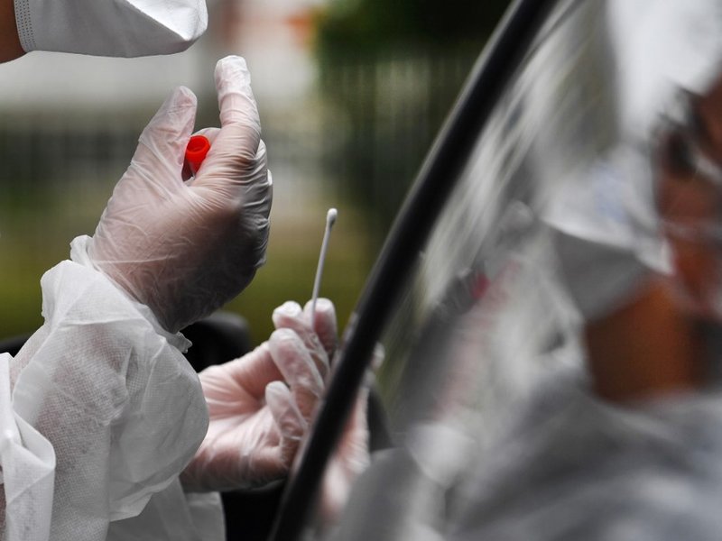 A medical staff holds a nasal swab as he collects samples from a person at a COVID-19 (the novel coronavirus) drive-in test in Brest, western France,