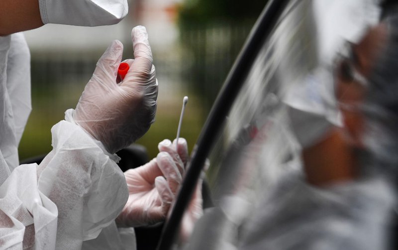 A medical staff holds a nasal swab as he collects samples from a person at a COVID-19 (the novel coronavirus) drive-in test in Brest, western France,