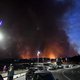 People look from a distance at a column of smoke as wild fires broke out in Sausset-les-Pins, near Marseille on August 4, 2020. Several fires were raging on August 4 evening near Marseille, with one particularly fuelled by strong winds, ravaging nearly 30