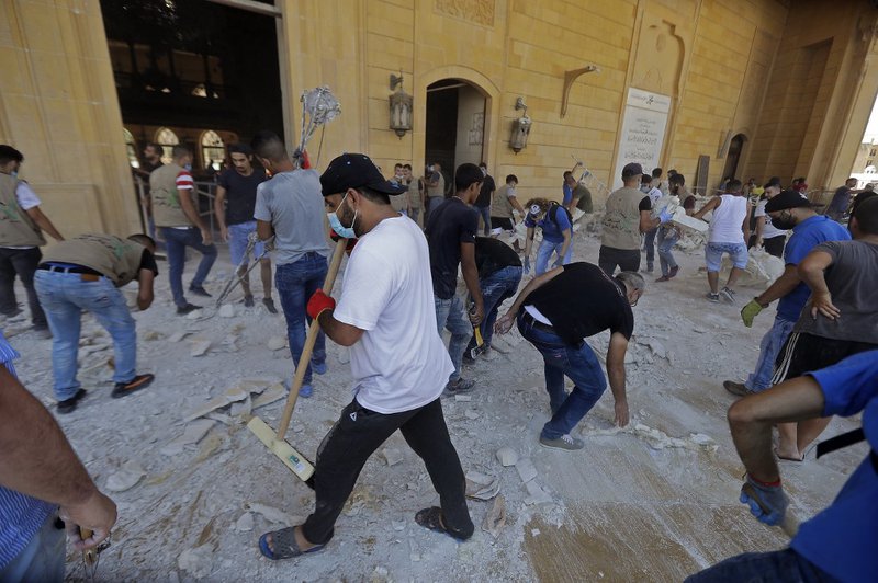 People clean debris at Mohammed al-Amin mosque in the centre of Beirut on August 5, 2020 in the aftermath of a massive explosion in the Lebanese capital. Rescuers searched for survivors in Beirut after a cataclysmic explosion at the port sowed devastation