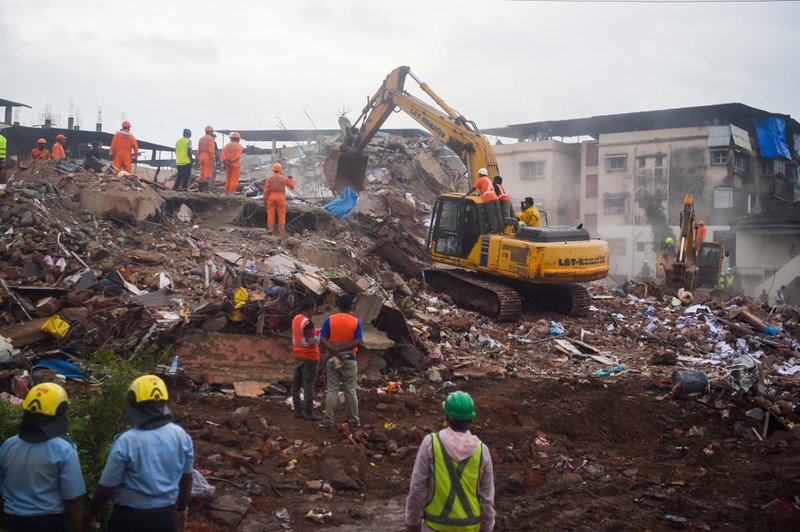 Rescue workers search for people in the rubble of a collapsed five-storey apartment building in Mahad on August 25, 2020. One person was killed and dozens feared trapped after a five-storey apartment building collapsed late August 24 in western India, off