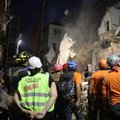 Lebanese and Chilean rescue workers watch as a crane lifts pieces of cement from a badly damaged building in Lebanon's capital Beirut, in search of possible survivors from a mega-blast at the adjacent port one month ago, after scanners detected a pulse, e
