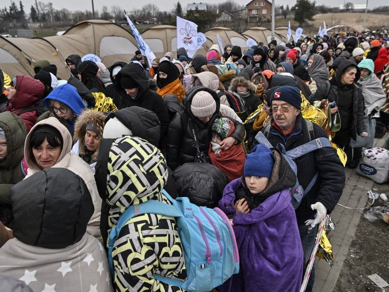 Refugees stand in line in the cold as they wait to be transferred to a train station after crossing the Ukrainian border into Poland, at the Medyka border crossing in Poland, on March 7, 2022. More than 1.5 million people have fled Ukraine since the start