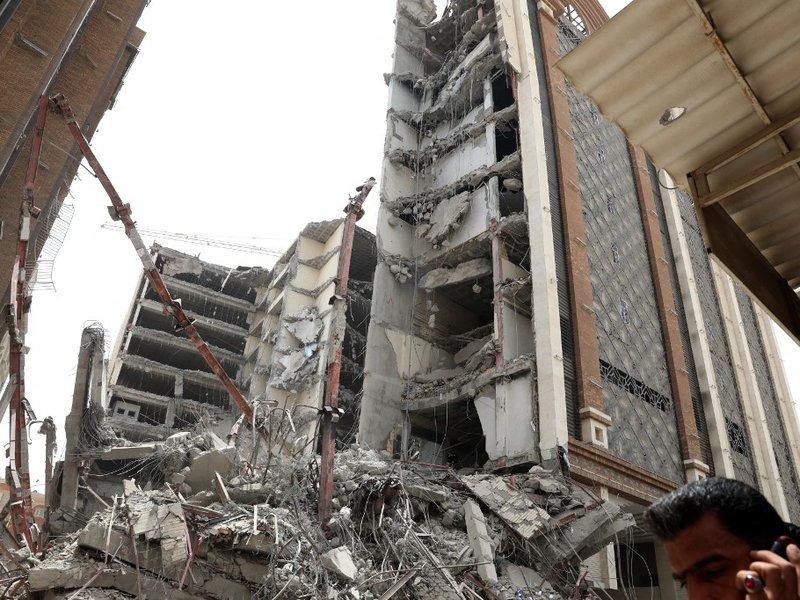 Iranians gather at the site where a ten-storey building collapsed in the southwestern city of Abadan on May 23, 2022. At least four people died and dozens were trapped under the rubble when an unfinished building collapsed in southwestern Iran, officials
