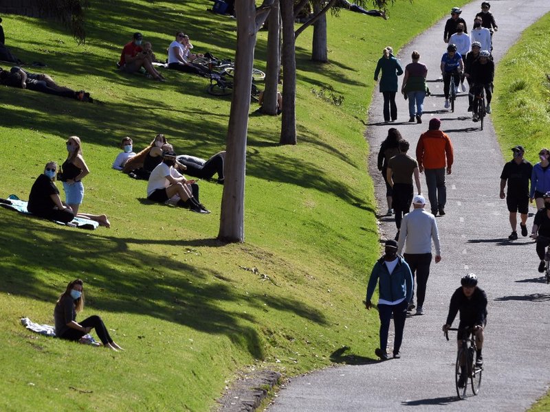 People exercise at a park along the Yarra River in Melbourne on September 27, 2020 as an overnight curfew in Australia's second-biggest city will be lifted from September 28, almost two months after it was imposed to counter a surging COVID-19 coronavirus