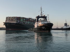 A handout picture released by the Suez Canal Authority on March 29, 2021 shows tugboats pulling the Panama-flagged MV 'Ever Given' (operated by Taiwan-based Evergreen Marine) container ship, a 400-metre- (1,300-foot-)long and 59-metre wide vessel, lodged