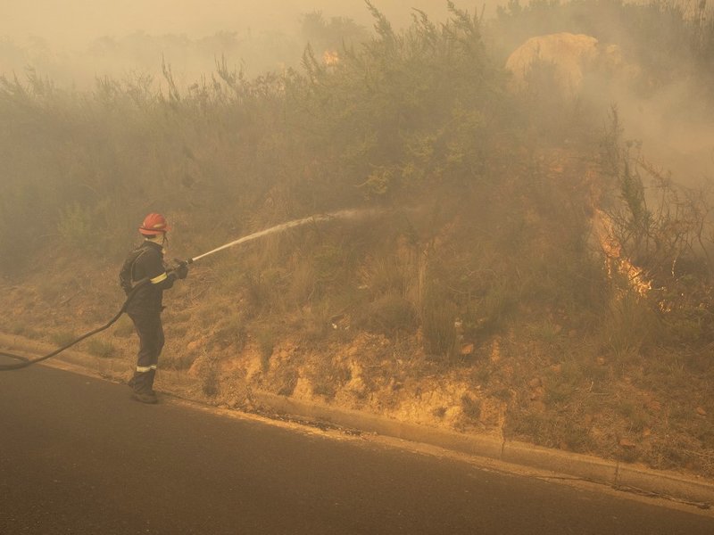 Fire-fighting teams work to keep the fire from crossing Philip Kgosana Drive, one of the main arterial roads into the city centre, threatening the suburb of Walmer Estate, after a forest fire burns out of control on the foothills of Table Mountain in Cape