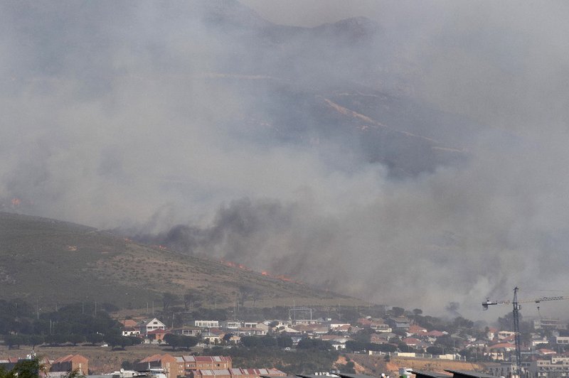 A general view of the forest fire, burning down the mountain towards Philip Kgosana Drive, one of the main arterial roads into the city centre, threatening the suburb of Walmer Estate, in Cape Town on April 19, 2021. The fire, which broke out on April 18,