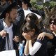 An Ultra-Orthodox Jewish woman comforts another at a cemetary in Benei Brak, as people attend the funeral of one of the victims of a stampede, when tens of thousands of people were gathered to celebrate the festival of Lag Ba'omer at a site in Meron in no