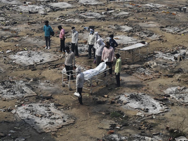 Relatives push a stretcher with the body of a victim who died due to the Covid-19 coronavirus at a cremation ground in New Delhi on May 5, 2021.