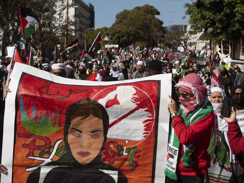 Demonstrators hold banners and wave Palestinian flags as they march through the city centre of Cape Town, South Africa, on May 11, 2021 to protest against Israeli attacks on Palestinians in Gaza as violence escalated between the bitter rivals sparked by u
