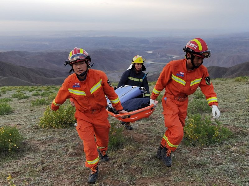 This photo taken on May 22, 2021 shows rescuers carrying equipment as they search for runners who were competing in a 100-kilometre cross-country mountain race when extreme weather hit the area, leaving at least 20 dead, near the city of Baiyin in China's
