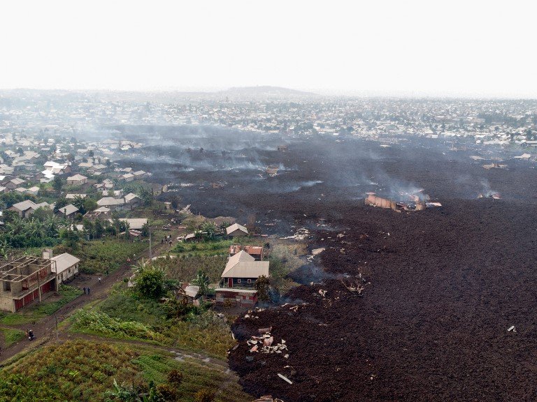 This aerial view shows debris engulfing buildings in Bushara village, Nyiragongo area, near Goma, on May 23, 2021, after a volcanic eruption of Mount Nyiragongo, that sent thousands fleeing during the night in eastern Democratic Republic of Congo. A river