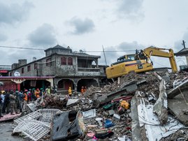 A bulldozer clears the rubble of a building that collapsed in the earthquake in Brefet, a neighborhood of Les Cayes, Haiti, on August 17, 2021. The death toll from a 7.2 magnitude earthquake that struck Haiti has risen to 1,941, the Caribbean nation's civ