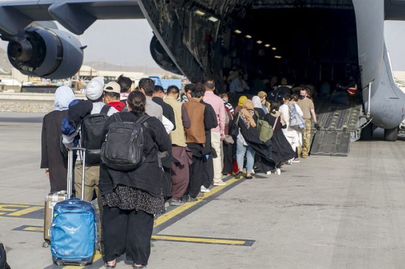 This handout photo courtesy of US Marines Corps shows evacuees stage before boarding a C-17 Globemaster III during an evacuation at Hamid Karzai International Airport, Kabul, Afghanistan, August 18, 2021.