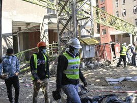 Contractors walk past a collapsed crane inside a construction site in Kenya's capital Nairobi, on August 26, 2021. The crane came crashing down while a team of 10 workers was attempting to dismantle it, eyewitnesses said.