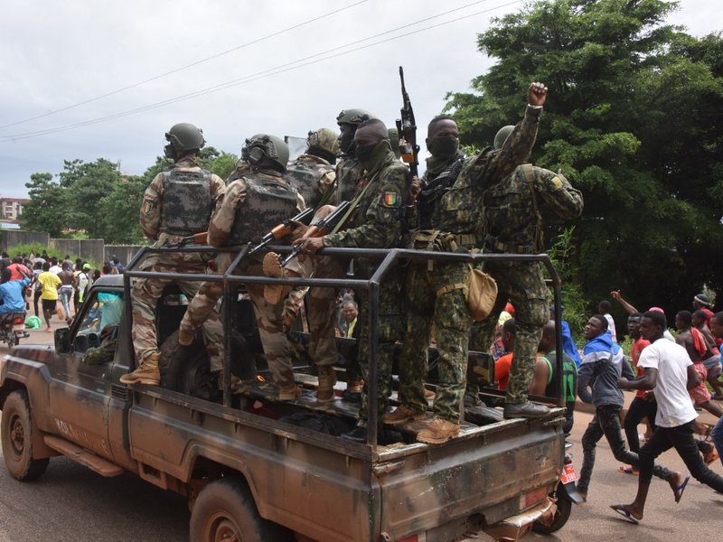 People celebrate in the streets with members of Guinea's armed forces after the arrest of Guinea's president, Alpha Conde, in a coup d'etat in Conakry, September 5, 2021. Guinean special forces seized power in a coup on September 5, arresting the presiden