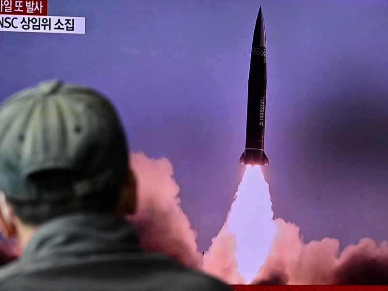 A man watches a television report showing a news broadcast with file footage of a North Korean missile test, at a railway station in Seoul on October 19, 2021, after the South's military said a North Korean weapons test was believed to be a submarine-laun