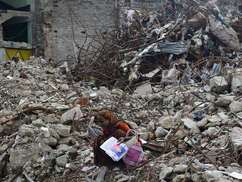 A mourner grieves for her relative, missing and presumed dead, at the scene of the April 24 Rana Plaza garment building collapse during the one hundredth-day anniversary of the disaster in Savar, on the outskirts of Dhaka, on August 2, 2013. Hundreds of g