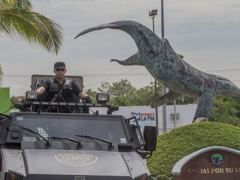A state police officer patrols a street during a security operation in Puerto Vallarta in the western Mexican state of Jalisco on August 18, 2016. Jesus Alfredo Guzman Salazar, the son of drug lord Joaquin "El Chapo" Guzman, was among a group kidnapped fr