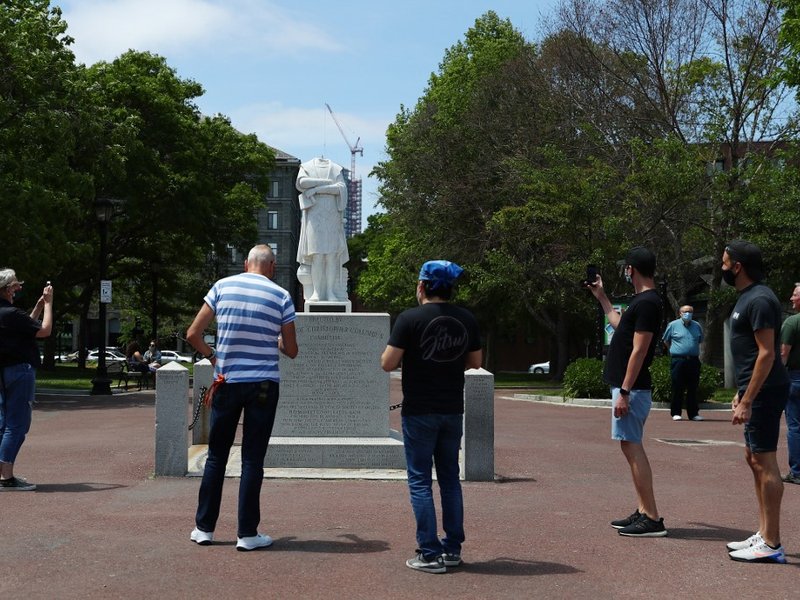 People photograph a statue depicting Christopher Columbus which had its head removed at Christopher Columbus Waterfront Park on June 10, 2020 in Boston, Massachusetts. The statue was beheaded overnight and is scheduled to be removed by the City of Boston.