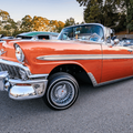 An orange classic Chevrolet at a car show