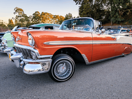 An orange classic Chevrolet at a car show