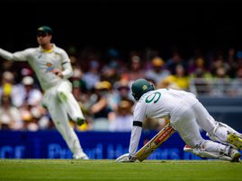 Proteas' Kyle Verreynne (R) slips as Australia's Travis Head (R) throws the ball