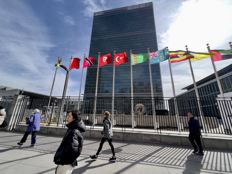 People walk past United Nations headquarters in New York