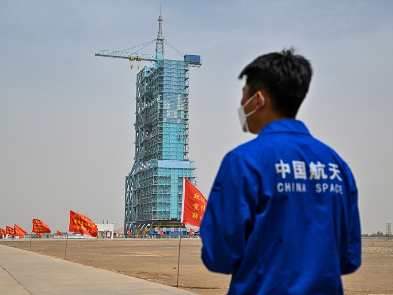 A staff member from the China space program stands before the launch platform of the Shenzhou-16 Manned Space Flight Mission one day before launch at the Jiuquan Satellite Launch Centre in China's northwestern Gansu province on May 29, 2023. (