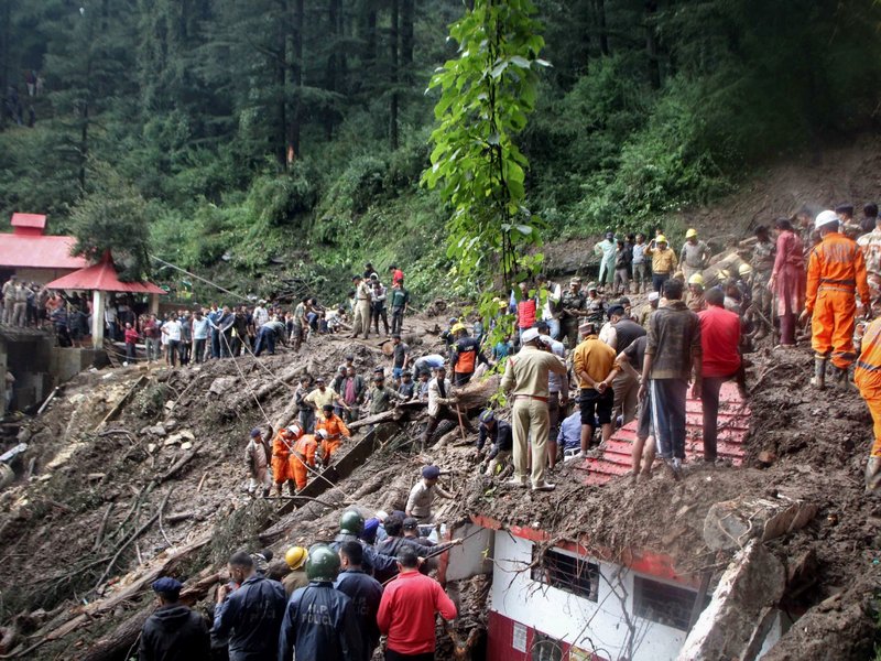 National Disaster Response Force (NDRF) personnel search for victims at the site of a landslide after a temple collapsed due to heavy rains in Shimla on August 14, 2023.