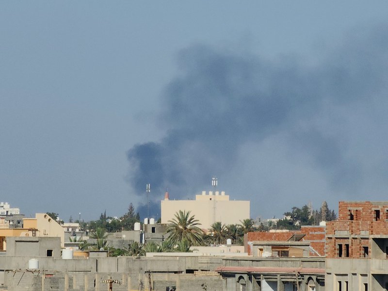 Smoke billows amid clashes between armed groups affiliated with Libya's Tripoli-based Government of National Unity (GNU) in the Libyan capital on August 15, 2023.