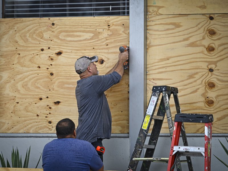 People board up a window in Tampa, Florida, on August 29, 2023 as the city prepares for Hurricane Idalia.