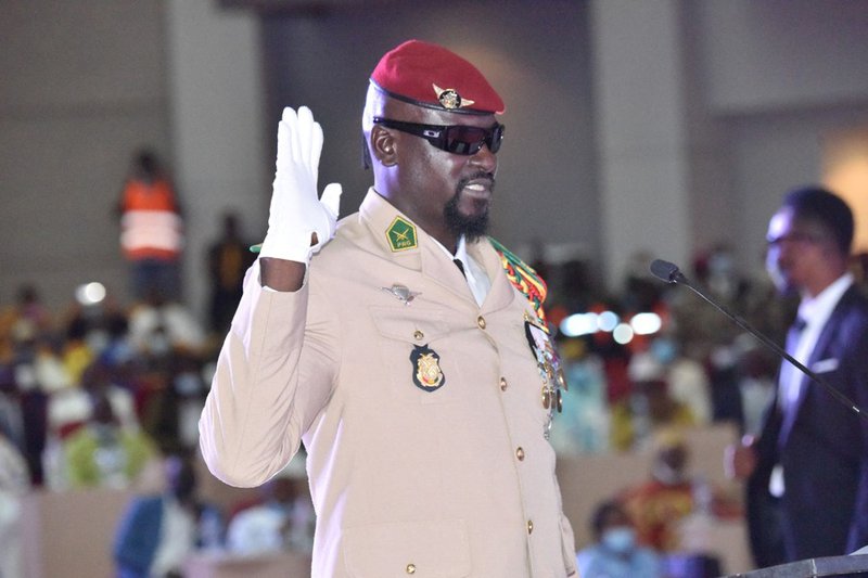 Guinea junta leader Colonel Mamady Doumbouya, raises his hand at his swearing in ceremony as president of country transion on October 1, 2021