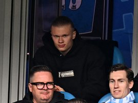 Erling Haaland looks on from his seat missing the game through injury