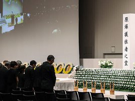 Attendees observe a moment of silence at the time of the 1945 atomic bombing at 11:02 am as they hold a peace memorial ceremony at an indoor facility due to approaching Typhoon Khanun in Nagasaki, Nagasaki prefecture on August 9, 2023 (JIJI Press / AFP)