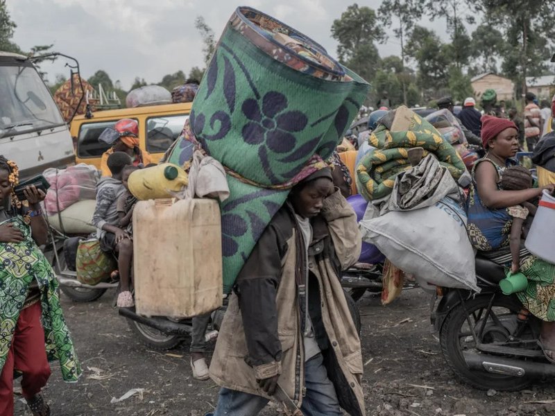 People carry their belongings as they flee eastern DRC