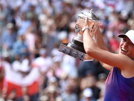 Poland's Iga Swiatek celebrates with the trophy after winning against Italy's Jasmine Paolini at the end of their women's singles final match on Court Philippe-Chatrier