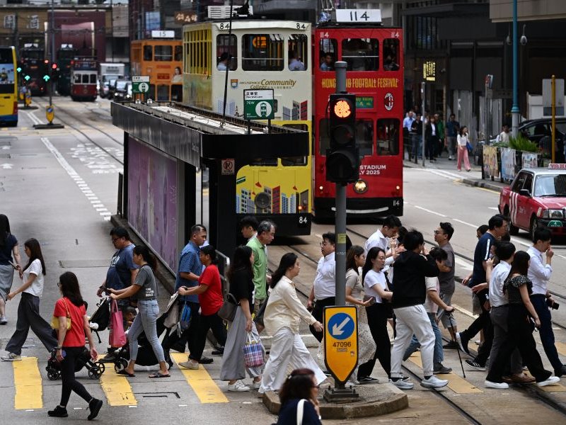 People cross a street in Hong Kong