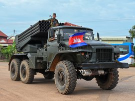 A Cambodian soldier stands on a truck carrying a Russian-made BM-21 rocket launcher