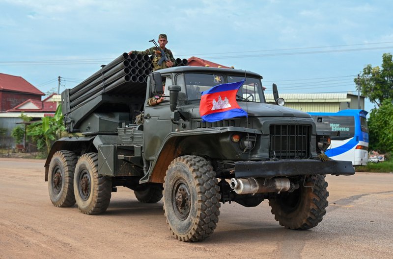 A Cambodian soldier stands on a truck carrying a Russian-made BM-21 rocket launcher